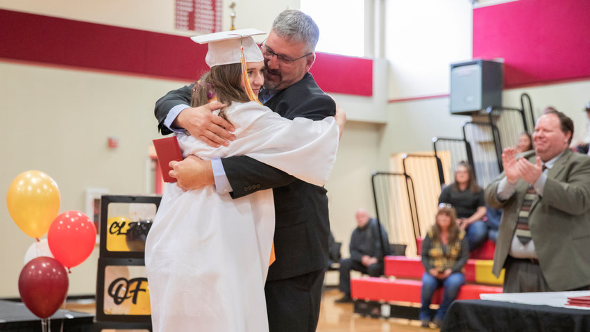 Madison Vigre receives and embrace with her diploma during a graduation ceremony Saturday at Winlock High School.