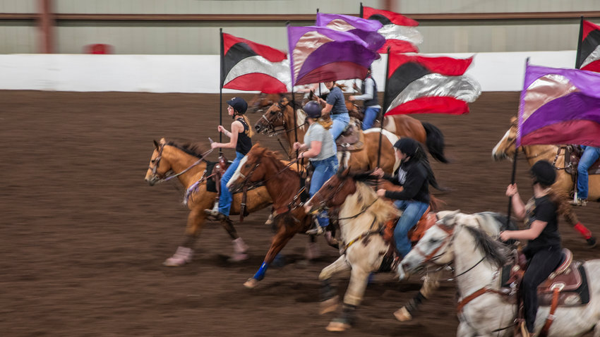 Savanna Ridley leads a formation carrying a flag on horseback in Salkum&rsquo;s Rocky Top Arena.