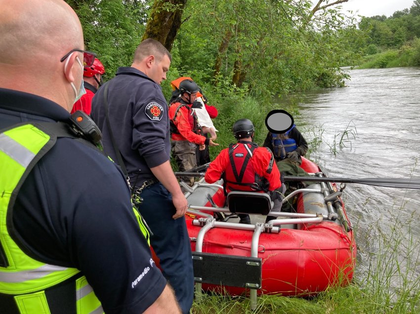 Technical rescue personnel and an AMR paramedic assist in removing rescue victims from Raft 23.