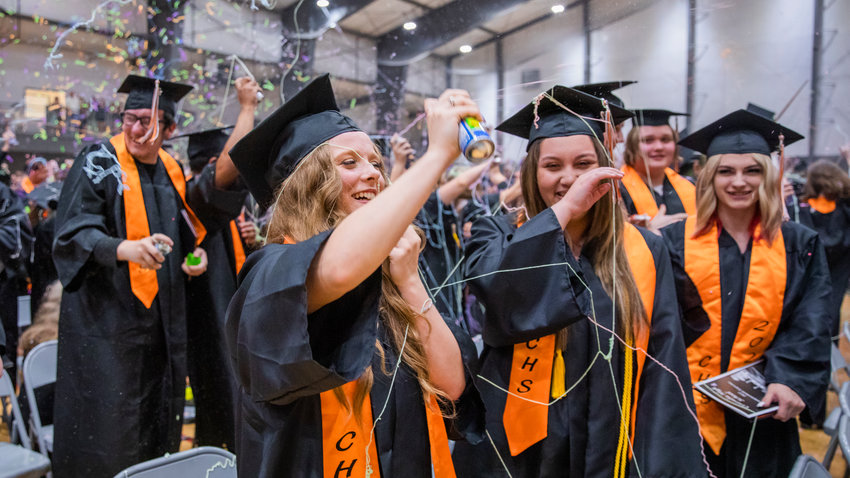 Graduates smile as they are hit with Silly String during celebrations in the Northwest Sports Hub on Friday.
