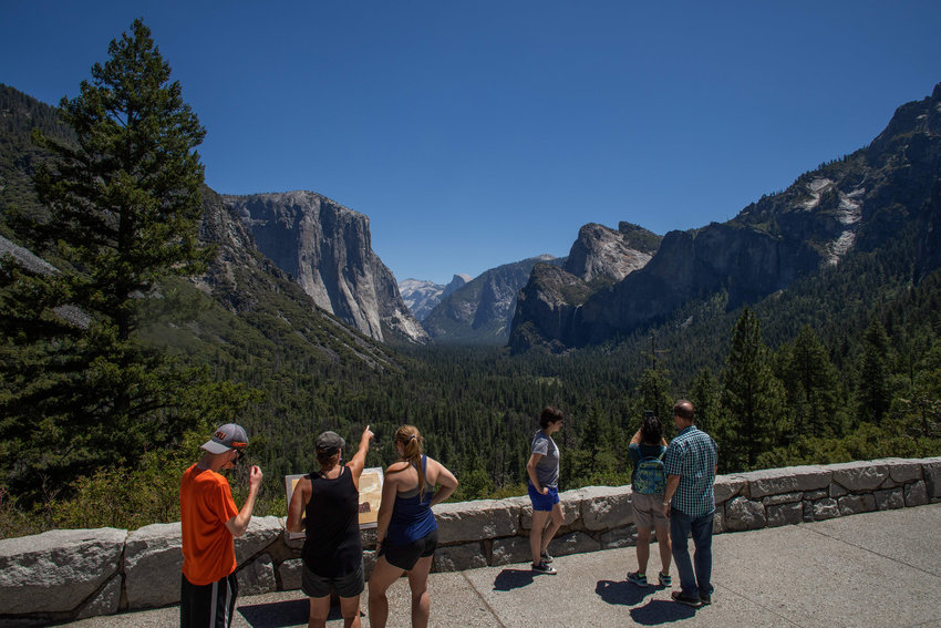 Visitors walk to the Tunnel View lookout in Yosemite Valley at Yosemite National Park, California on July 8, 2020. (Apu Gomes/AFP/Getty Images/TNS)