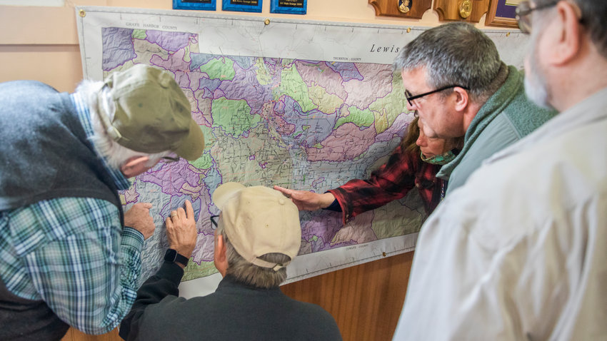 West Lewis County residents gather around a map representing possible isolation zones that would occur from bridge collapses and landslides in the 9.0 magnitude Cascadia Subduction Zone earthquake at the Baw Faw Grange on Monday.