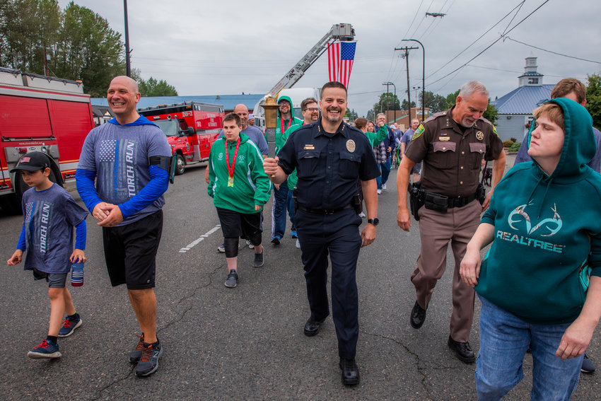 Centralia Police Chief Stacy Denham smiles while leading a group during the Lewis County Law Enforcement Torch Run for the Washington Special Olympics on Friday.