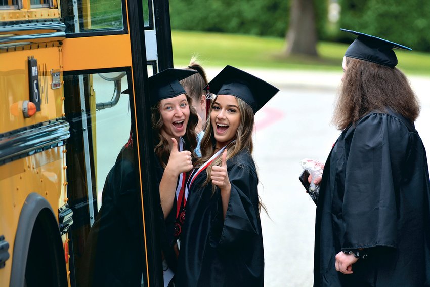 Seniors at Yelm High School give a thumbs up before they enter a bus after the annual grad walk through schools on June 15.