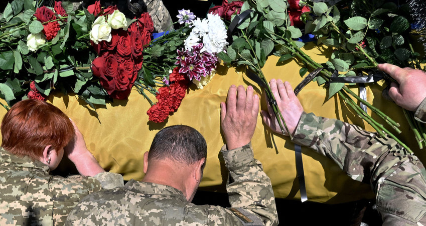 Ukrainian servicemen mourn on the coffin of their comrade Oleh Kutsyn, commander of the &quot;Karpatska Sitch&quot; battalion killed during the war against Russia, during a funeral ceremony at Kyiv's &quot;Maidan&quot; Independence Square on June 22, 2022. (Sergei Supinsky/AFP/Getty Images/TNS)