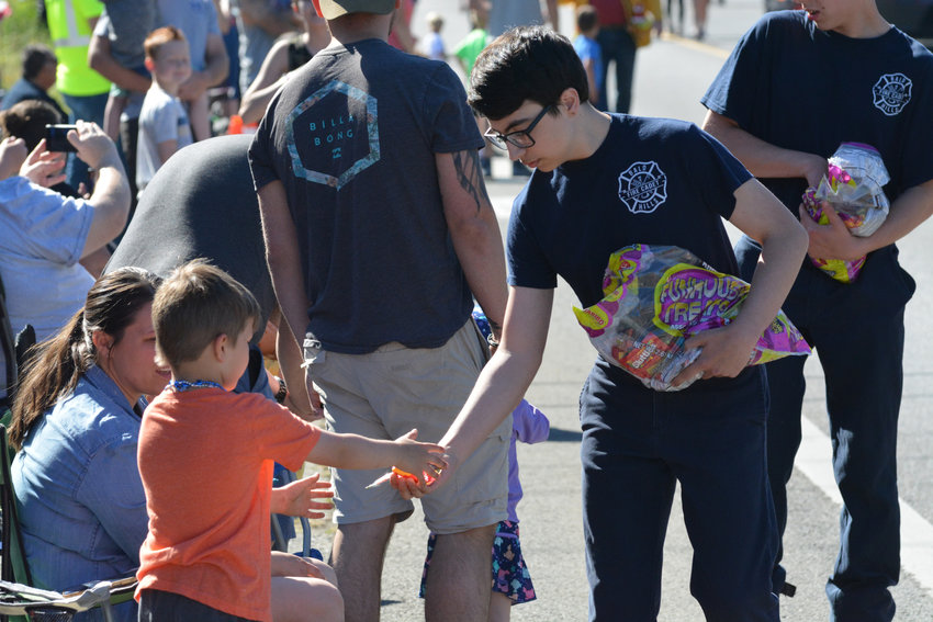 A Bald Hills fire cadet gives candy to a kid during a the Prairie Days Parade in 2022.