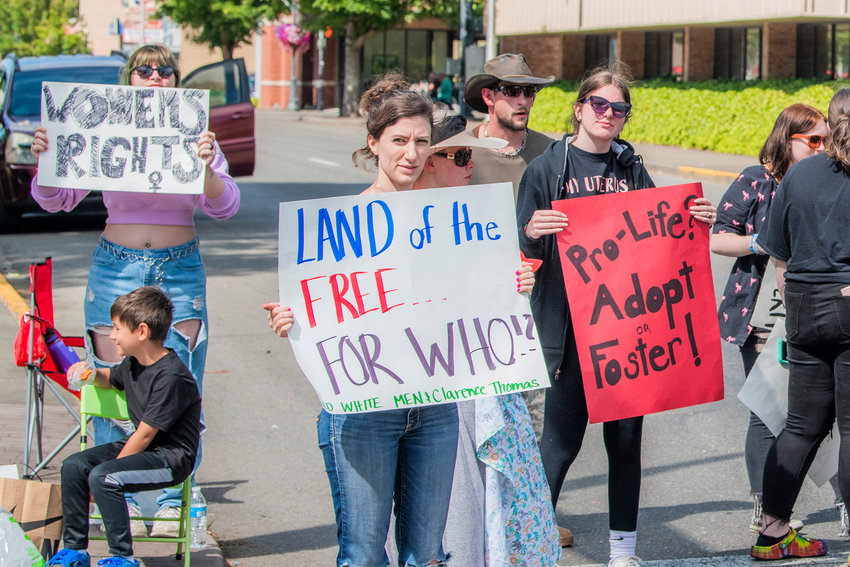 Protesters hold pro-life signs for women's rights along South Pearl Street in downtown Centralia before the start of the Centralia Summerfest parade in July 2022.