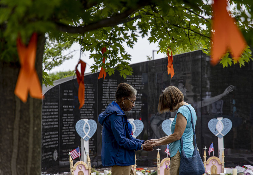 Frieda R. and Penny Laing pray together at a growing memorial near the Central Avenue scene on July 6, 2022, two days after a mass shooting at the Fourth of July parade in Highland Park. (Brian Cassella/Chicago Tribune/TNS)