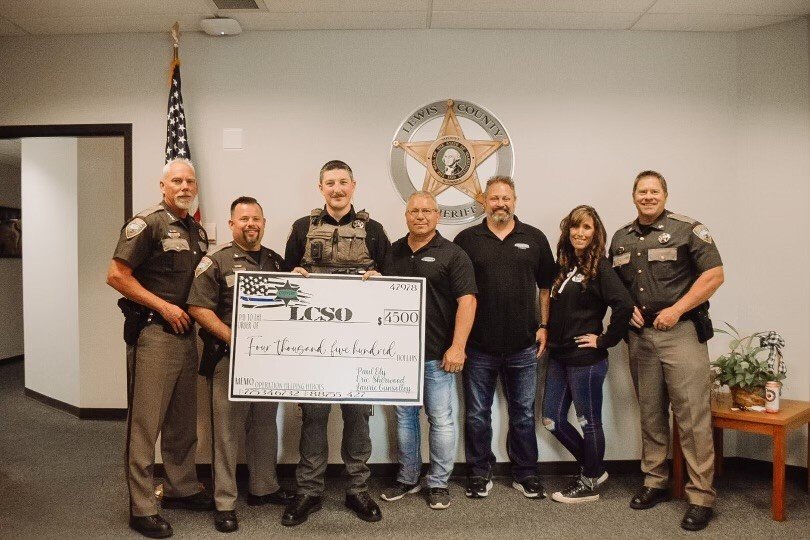 Country Financial agents deliver a $4,500 check to Lewis County Sheriff&rsquo;s Office staff in Chehalis on Thursday.