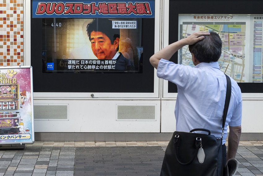 A man looks at a television broadcast showing news about the attack on former Japanese prime minister Shinzo Abe earlier in the day, along a street of Tokyo on July 8, 2022. - Shinzo Abe was shot at a campaign event in the city of Nara on July 8, a government spokesman said, as local media reported the nation's longest-serving premier was showing no vital signs. (Charly Triballeau/AFP via Getty Images/TNS)
