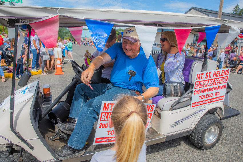 Candy and smiles are shared from the Mount St. Helens Bluegrass Festival float Saturday during the Cheese Days parade in downtown Toledo.