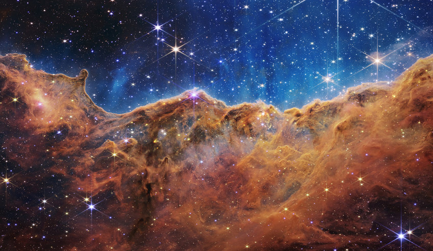 This landscape of &quot;mountains&quot; and &quot;valleys&quot; speckled with glittering stars is actually the edge of a nearby, young, star-forming region called NGC 3324 in the Carina Nebula. Captured in infrared light by NASA&rsquo;s new James Webb Space Telescope, this image reveals for the first time previously invisible areas of star birth. (NASA, ESA, CSA, and STScI/TNS)