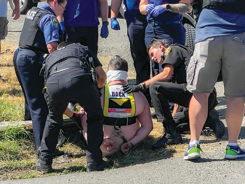 Law enforcement and paramedics check the condition of a man after tasers were deployed Tuesday in Chehalis.