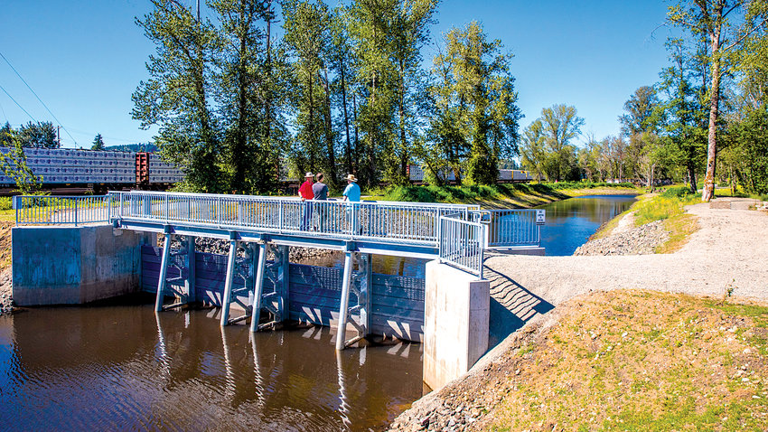 Visitors walk on a path on a a flood-control weir over China Creek Tuesday in Centralia.