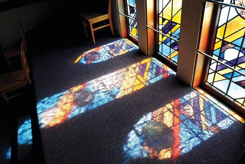 Sunlight shines through stained glass windows onto the balcony floor at the Toledo Presbyterian Church on Saturday, July 9, in Toledo. The church's goal is to raise $75,000 in funds to help restore the old windows.