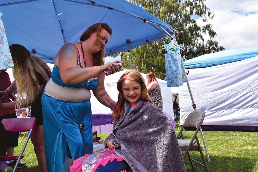 A girl gets her hair colored at the 2021 Yelm Mermaid Festival. This year&rsquo;s event is set for Saturday, July 30, at Yelm City Park.