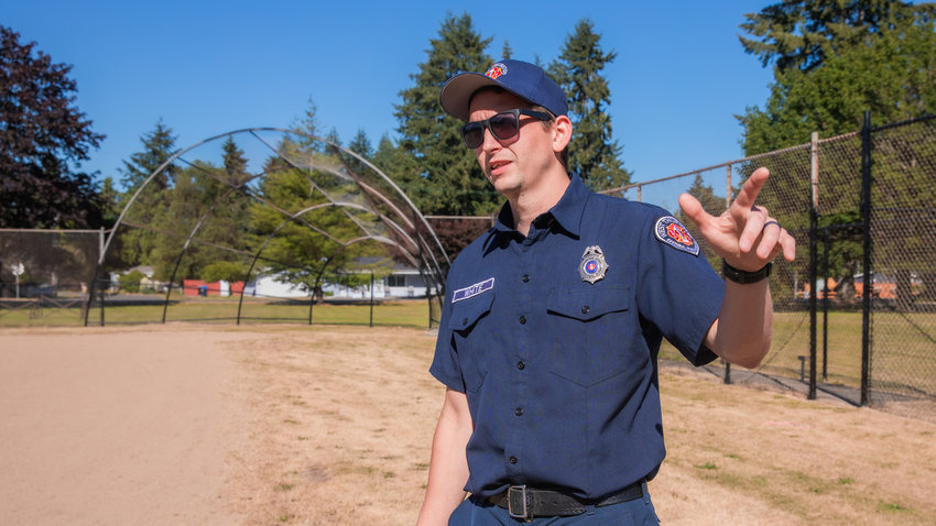 West Thurston Firefighter Chris White talks about new fencing and paint around the baseball field outside the Scott Lake Community Center near Maytown.