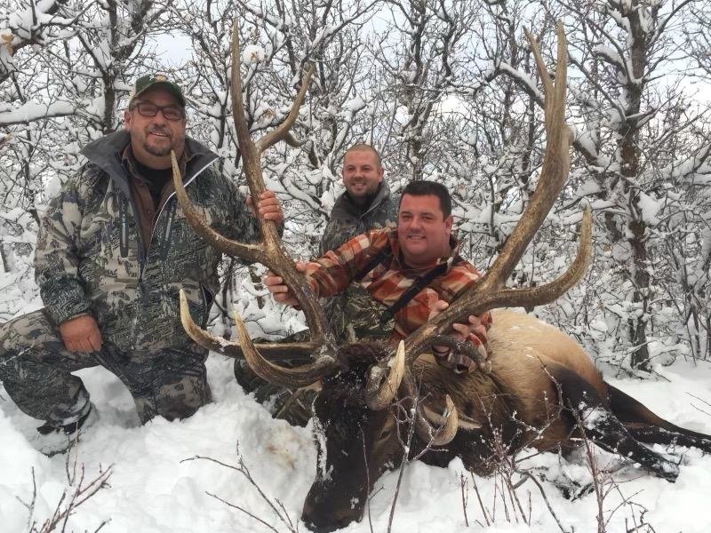 David Creagan poses with an elk with his friends on a hunting trip.