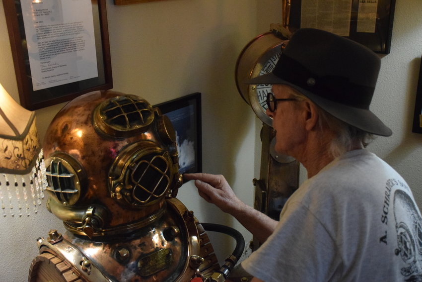Navy diving equipment collector Bradley Mitchell looks at one of his &ldquo;hard hat&rdquo; diving helmets in a room at his house dedicated to his collection.