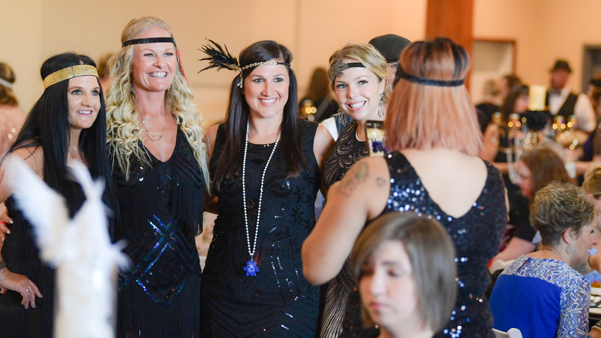 From left, Jody Hill Laeger, Terry Wentworth, Britney Britton, and Jessica Kirker smile and pose for a photo during a Power of the Purse event last August at Jester&rsquo;s Auto Museum in Chehalis.