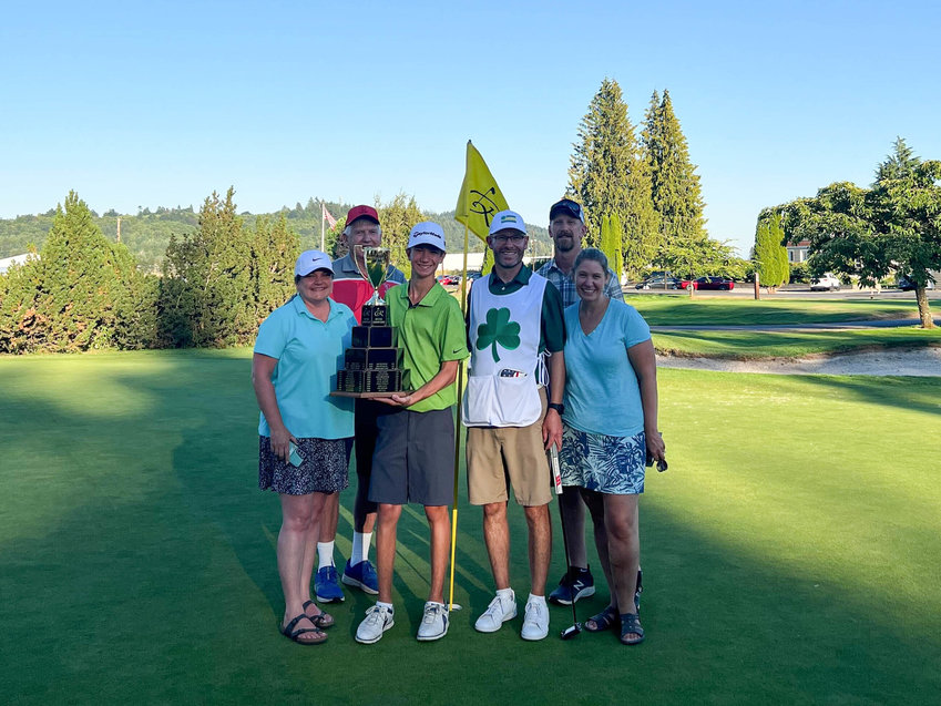 Eli McNelly holds the Lewis County Amatuer trophy after his two-day total of 140 helped him take home the title, joined by his family.