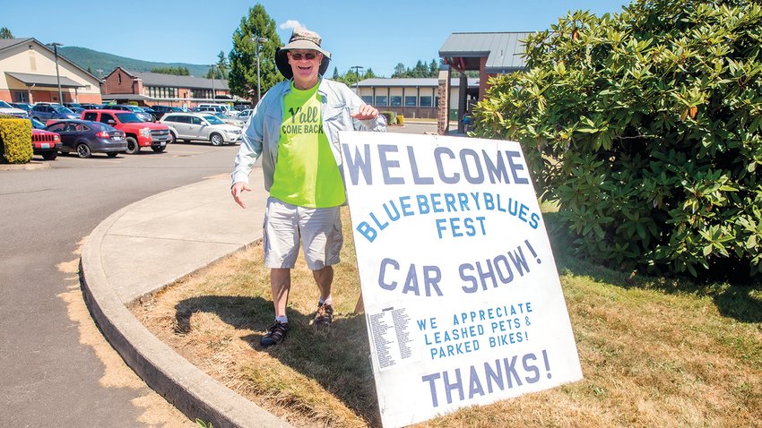 Dean Darnell welcomes visitors to the Blueberry Blues Fest Car Show in Mossyrock in 2022 with signage.