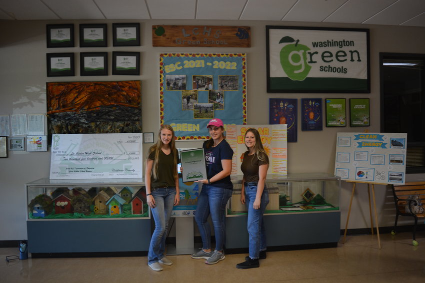 Officers from La Center High School&rsquo;s Environmental Action Team show off their Green Ribbon Award plaque in front of the team&rsquo;s display at the school on Aug. 2.