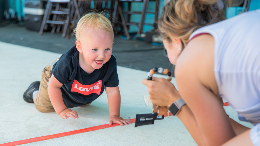 Parker Vermilyea, 14 months, from Toledo, crosses the finish line before taking first place during the diaper derby races Thursday afternoon at the Southwest Washington Fairgrounds.