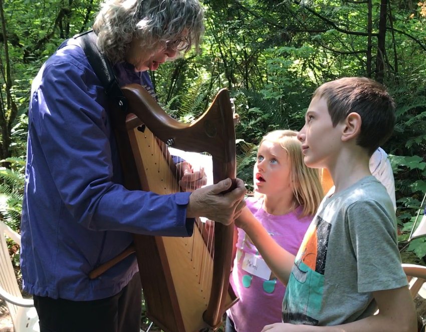 Children react with astonishment after plucking the strings of a harp during the 2017 Music on the Hill event. This year&rsquo;s event will be held at 10 a.m. this Saturday, Aug. 27, at the Seminary Hill Natural Area.