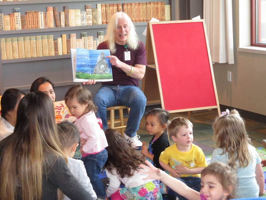 Mike McGowan reads a story about the moon to a room full of toddlers, babies and their caregivers at the Yelm library in this file photo.