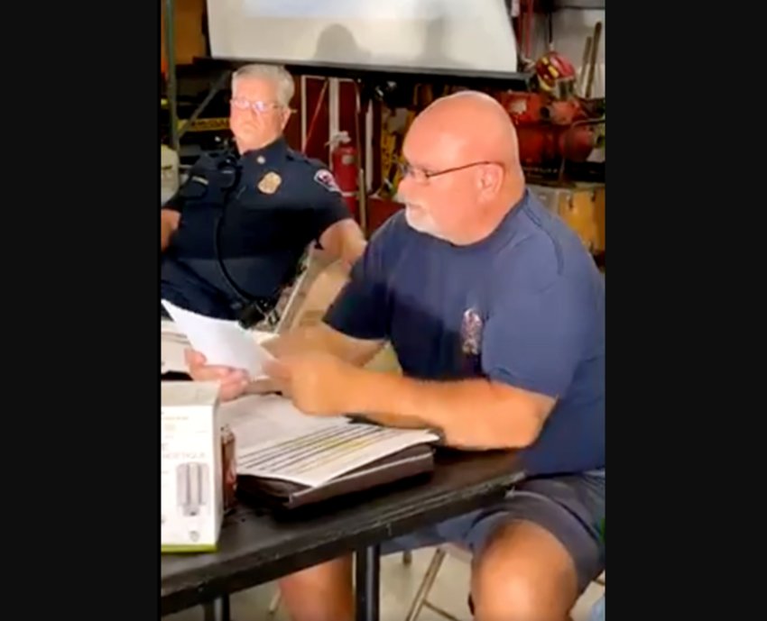District 11 Chief Miles Burmeister, right, reads a prepared statement at an emergency community meeting held at District 11's fire station in Pe Ell on Monday while District 15 Chief Rich Underdahl looks on.