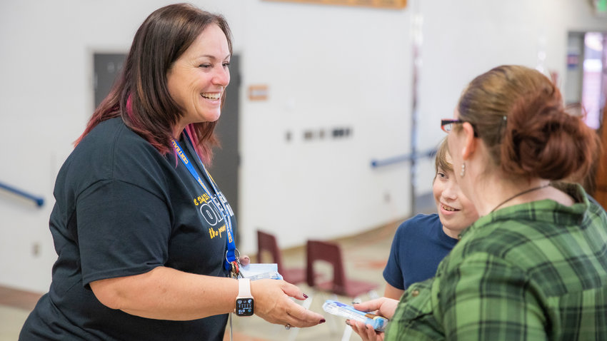 Centralia Middle School Principal Lara Gregorich-Bennett smiles while greeting visitors and handing out ice cream bars Thursday afternoon during an open house event for students and families.