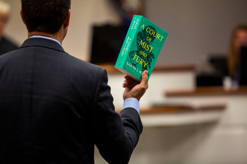 Petitioner Tim Anderson holds up one of the books in question, A Court of Mist and Fury, during an obscenity lawsuit hearing in Virginia Beach Circuit Court on Tuesday, Aug. 30, 2022. (Kendall Warner/The Virginian-Pilot/TNS)