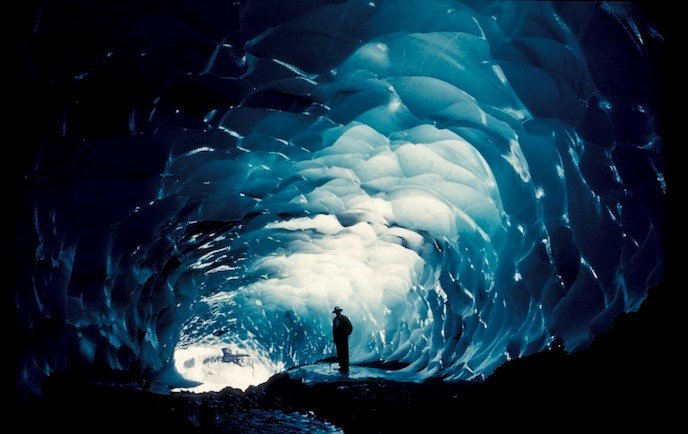 A visitor stands near the entrance of one of Paradise ice caves. This photo was taken in 1958. Due to the retreat of the glacier, these caves no longer exist.