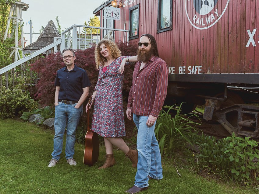 From left to right, Michael Falcone, Fae Wiedenhoeft and Adam Chambers pose in front of the caboose when in it was still in Bothell.
