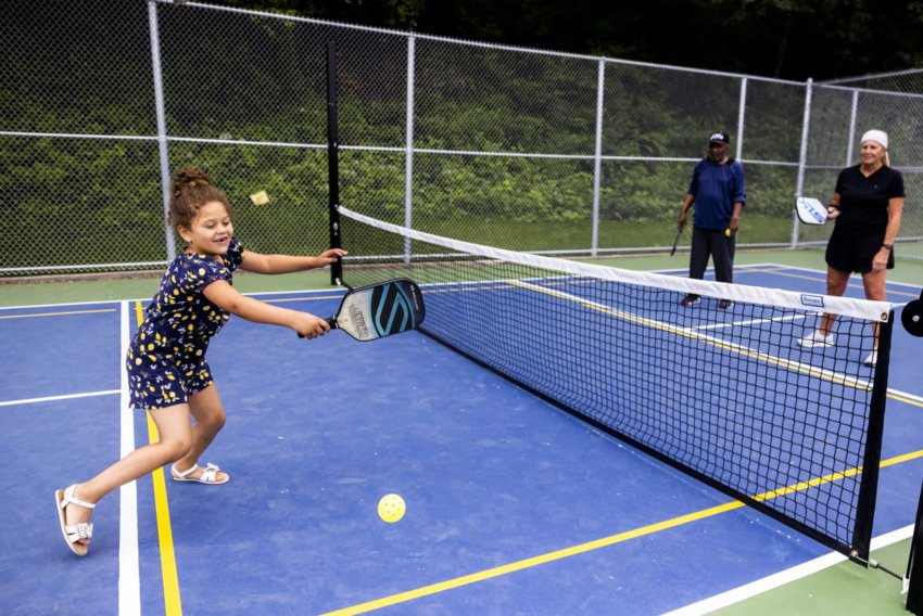 Amara Erickson, 5, left, smiles as she plays her first game of pickleball at Lakeridge Playfield on July 2, 2022. Pickleball is the official sport of the state of Washington. The game was invented on Bainbridge Island in 1965.