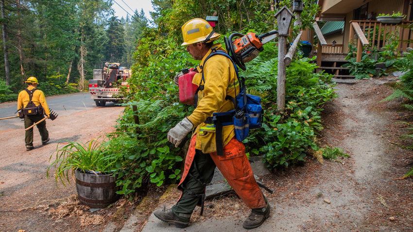 Firefighters carry gear while conducting structural triage in the upper Timberline area in September 2022 while responding to the Goat Rocks Fire.