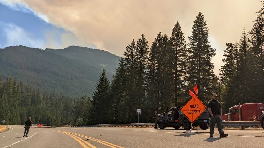 At right, Lewis County Sheriff&rsquo;s Office Field Operations Chief Dusty Green walks to his patrol vehicle on U.S. Highway 12 Sept. 10 as Sheriff Rob Snaza stands in the closed road to observe smoke from the Goat Rocks Fire.