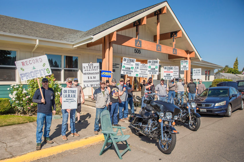 Loggers, drivers, mechanics, road maintenance workers and other employees of Weyerhaeuser continue to strike into Monday standing with signs along North Pearl Street in Centralia. The strike began last week. Workers say wages, health care and welfare are among the sticking points in contract negotiations.