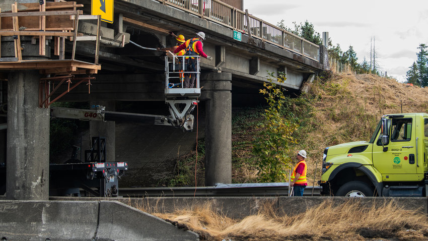 WSDOT crews inspect damage on the state Route 506 overpass to Interstate 5 after it was struck by logging truck Thursday morning.