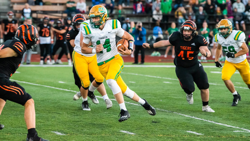 Tumwater senior Alex Overbay (14) keeps the football and looks upfield during a game against Centralia Friday night.