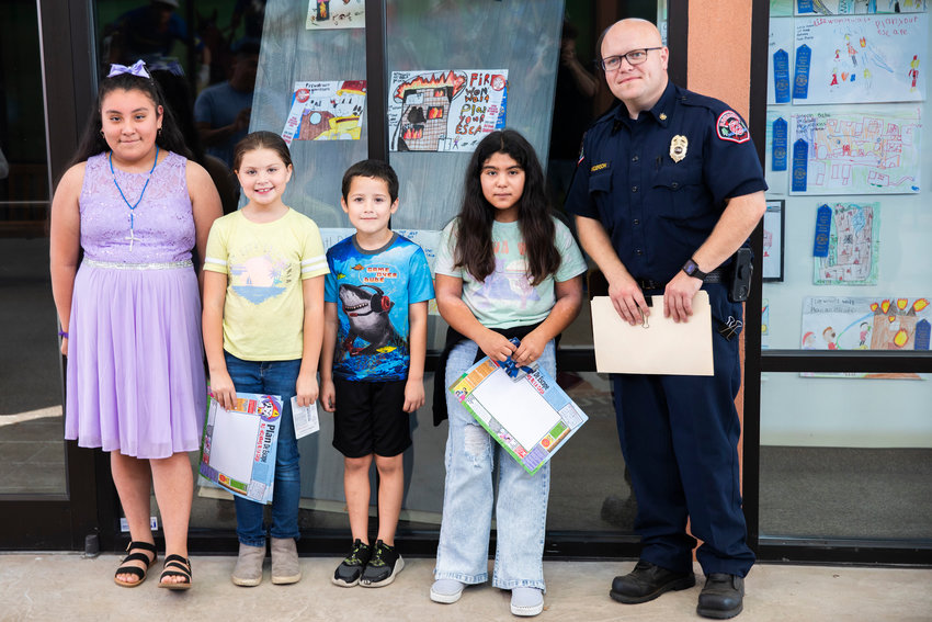 Students from left, Cynthia, Anabelle, Jesse, and April pose for a photo alongside Kevin Anderson with Riverside Fire Authority as Fire Prevention Week celebrates 100 years.