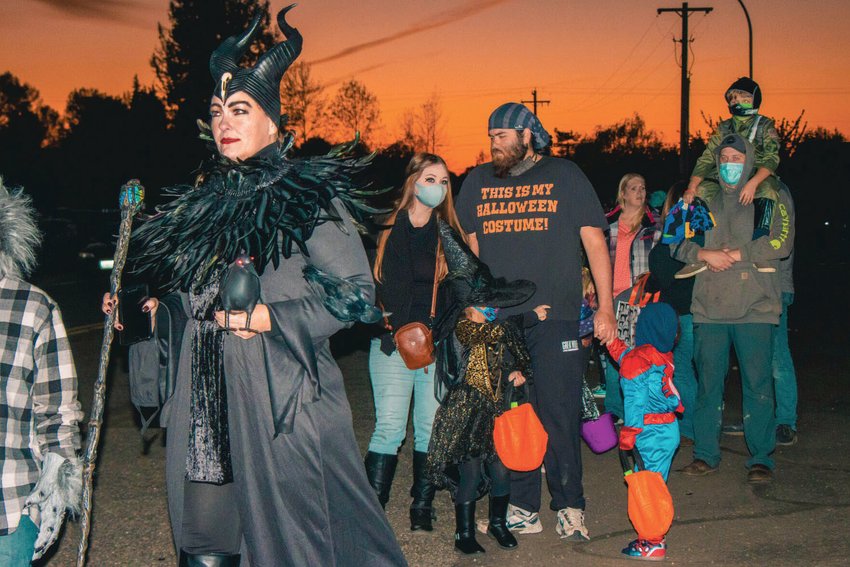 Community members decked out in Halloween attire wait in line for a trunk-or-treat event in this file photo.