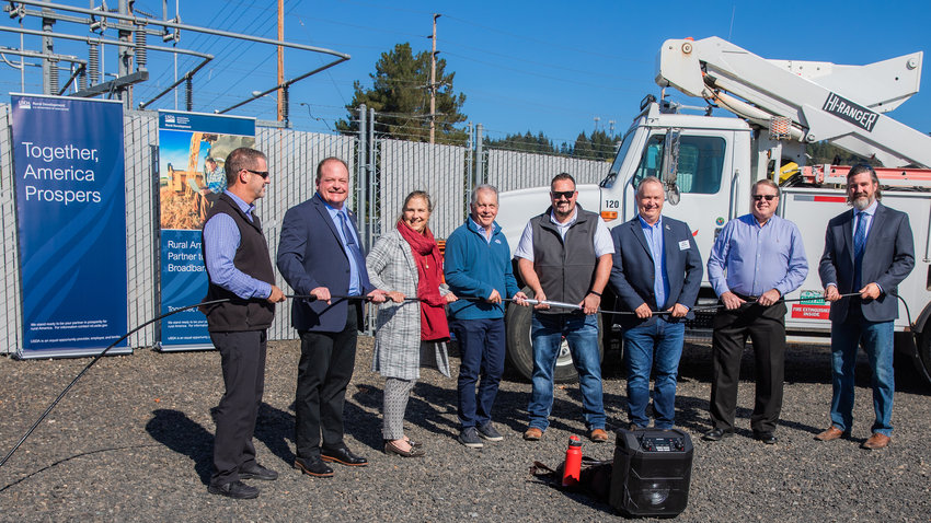 State and federal leaders smile for a photo on Wednesday in Chehalis at the Main Street Substation during a fiber project ribbon cutting event.
