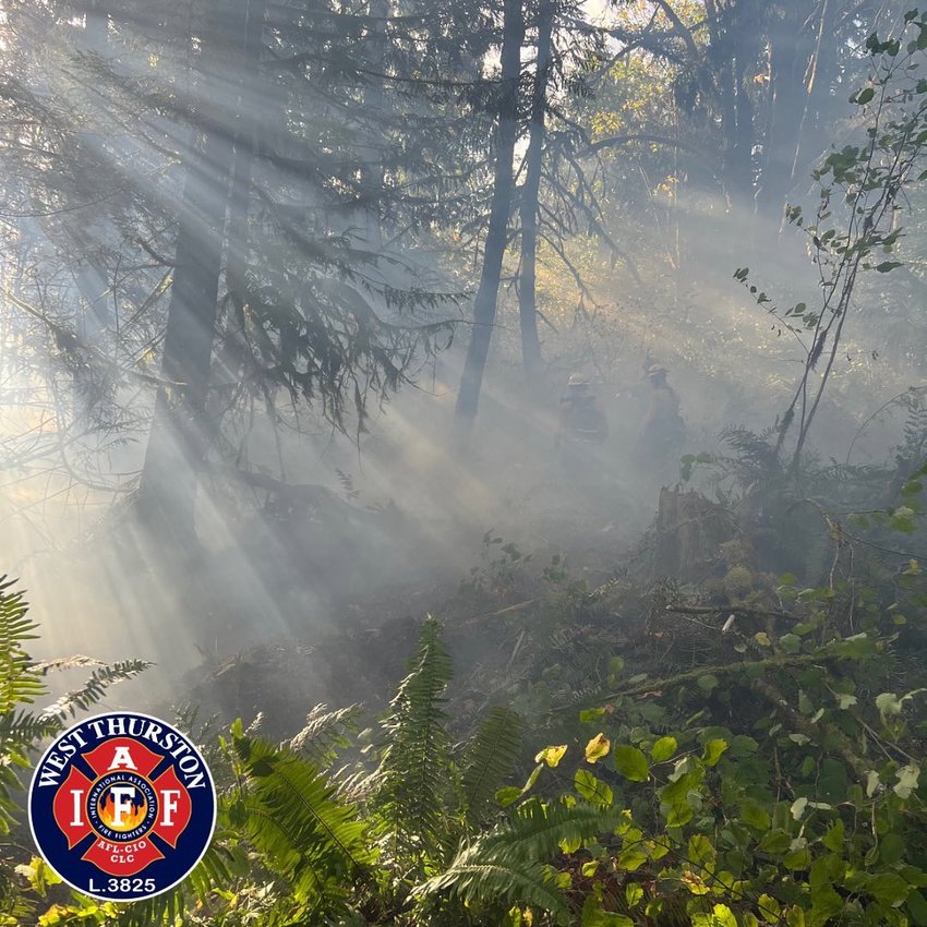 Firefighters are shrouded in smoke from a brush fire Monday near Tilley Road in South Thurston County.