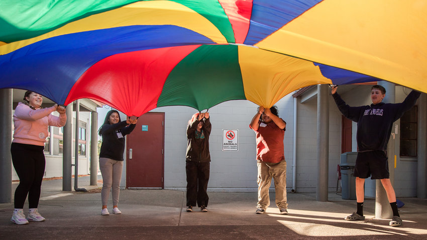 Freshmen students at W.F. West in Chehalis lift a parachute during an exercise with leaders from Camp Cispus on Wednesday.