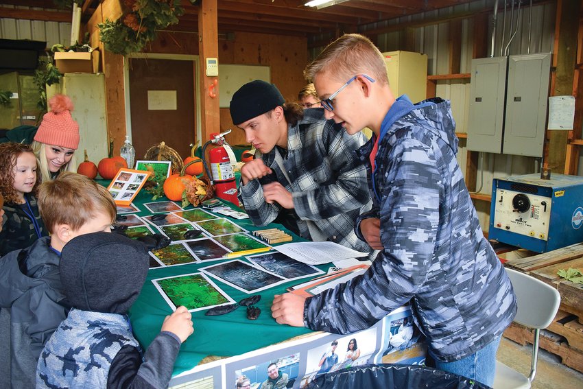 Battle Ground Public Schools&rsquo; Center for Agriculture, Science and Environmental Education students Dante Fornaciari, left, and Ryan Tapio, talk about animal tracks with Maple Grove Elementary School kindergarteners at the center on Oct. 21.