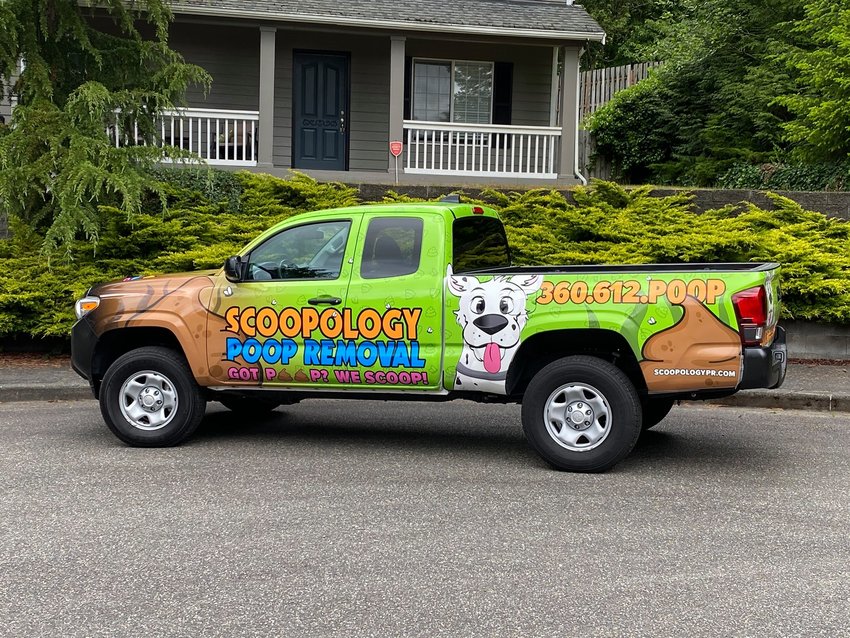 A vehicle with the pet waste removal company, Scoopology, advertises the business&rsquo; services.