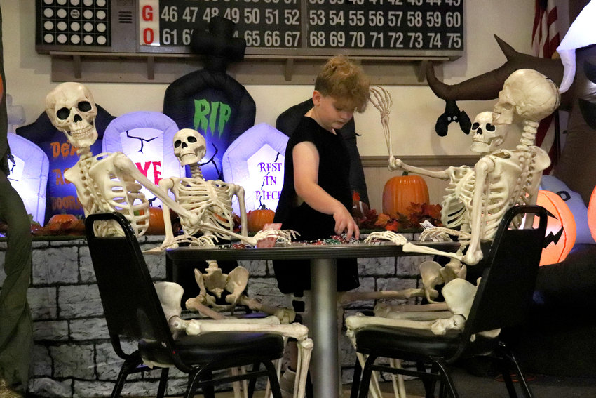 Jayden Cabell deals for a poker game between skeletons at the Chehalis Moose Lodge during the Halloween Children&rsquo;s Carnival on Saturday.