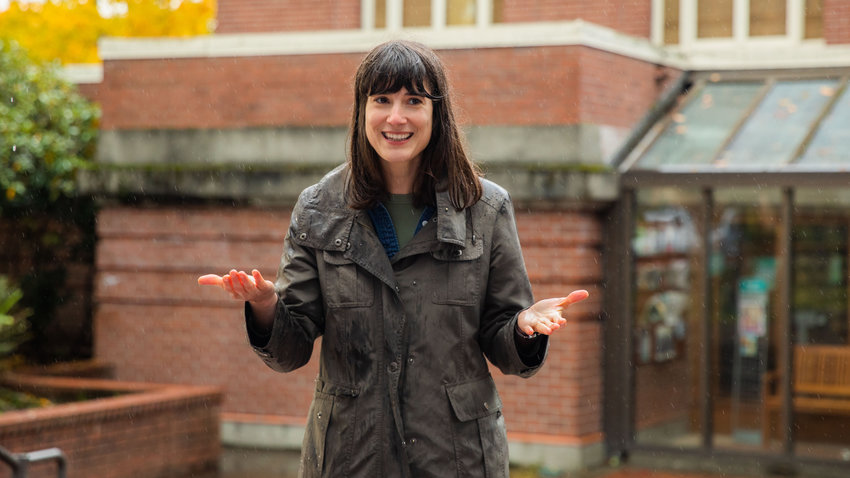Marie Gluesenkamp Perez smiles while standing in the rain and talking to supporters about her campaign outside the Centralia Timberland Library earlier this month.